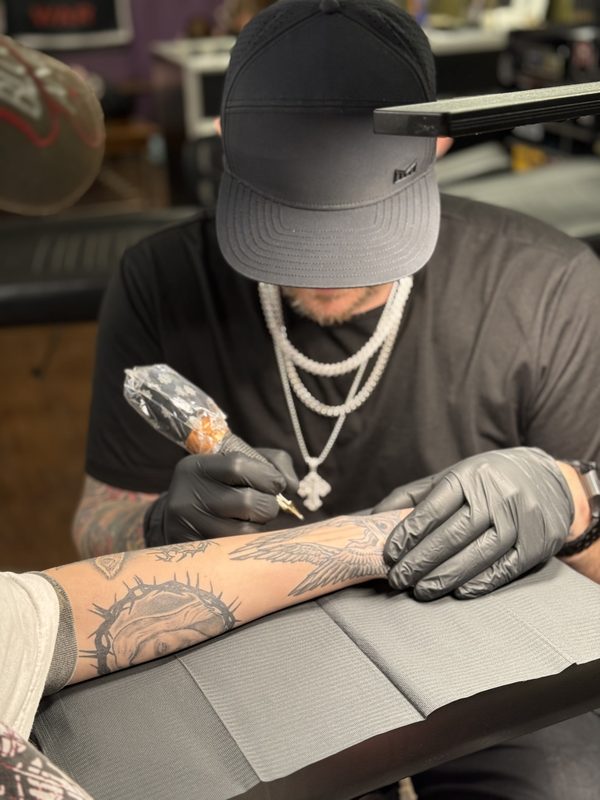 Lance Albright tattooing a client